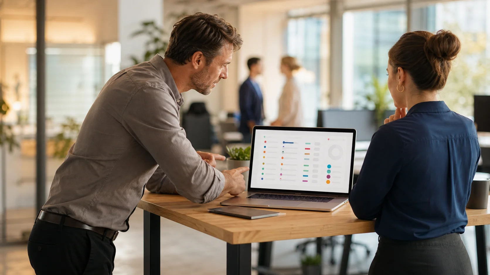 A procurement manager reviews upcoming contract renewals on a laptop dashboard at a modern office desk, natural light coming through large windows.